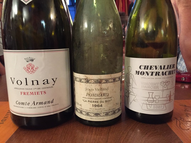 Three empty bottles of wine on table