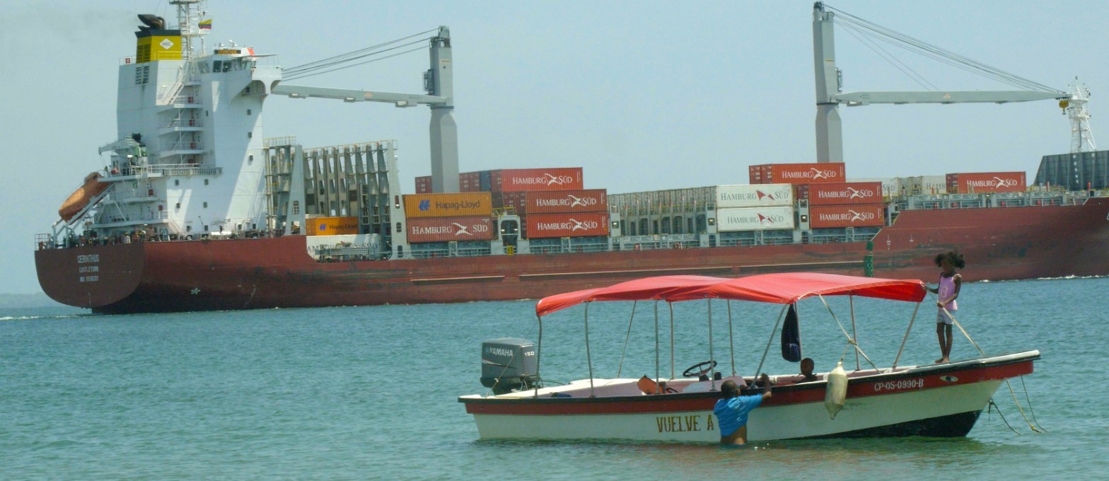 Family on a boat next to a freighter